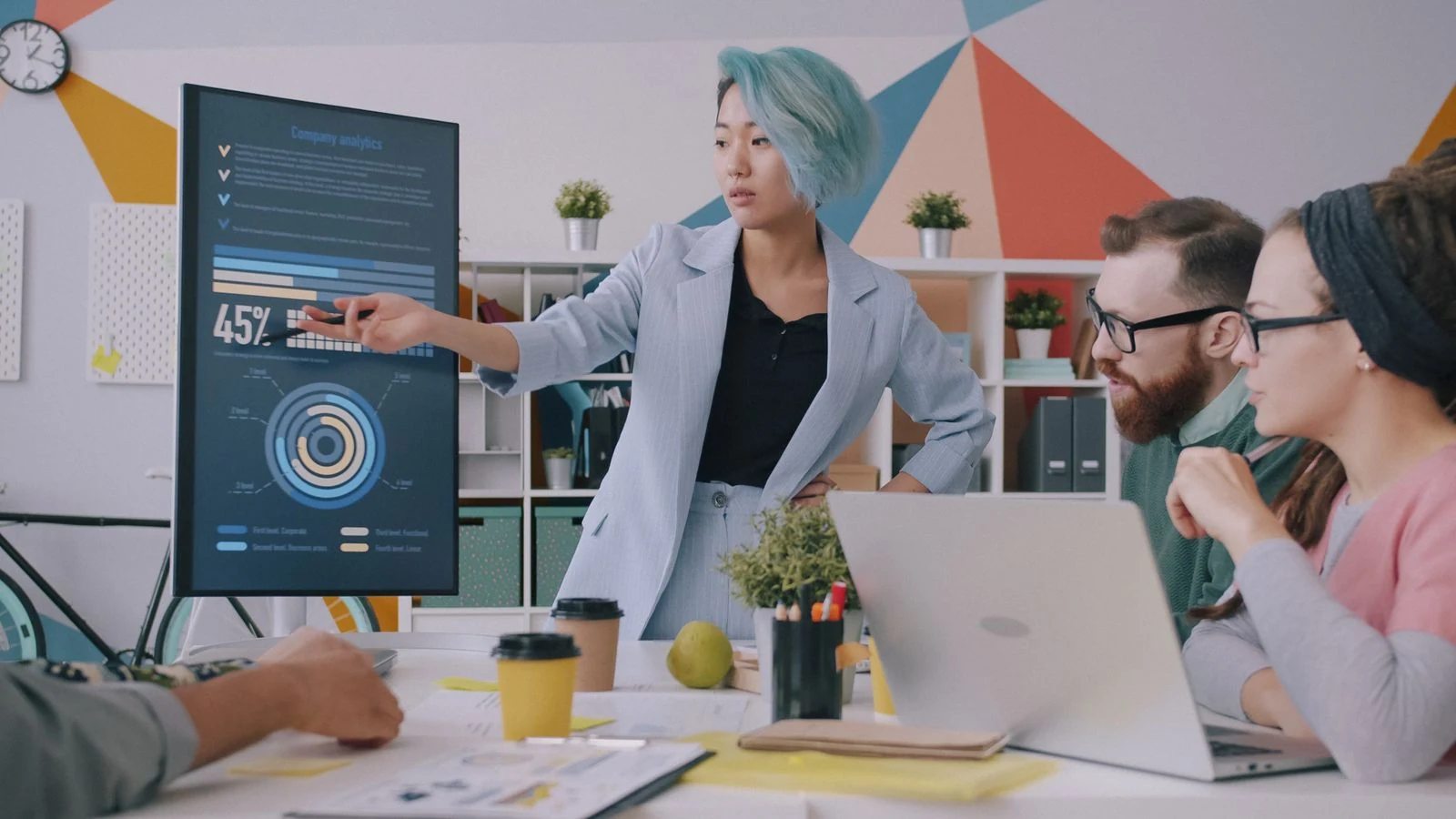 Professionals reviewing digital workflow analytics on a large office display