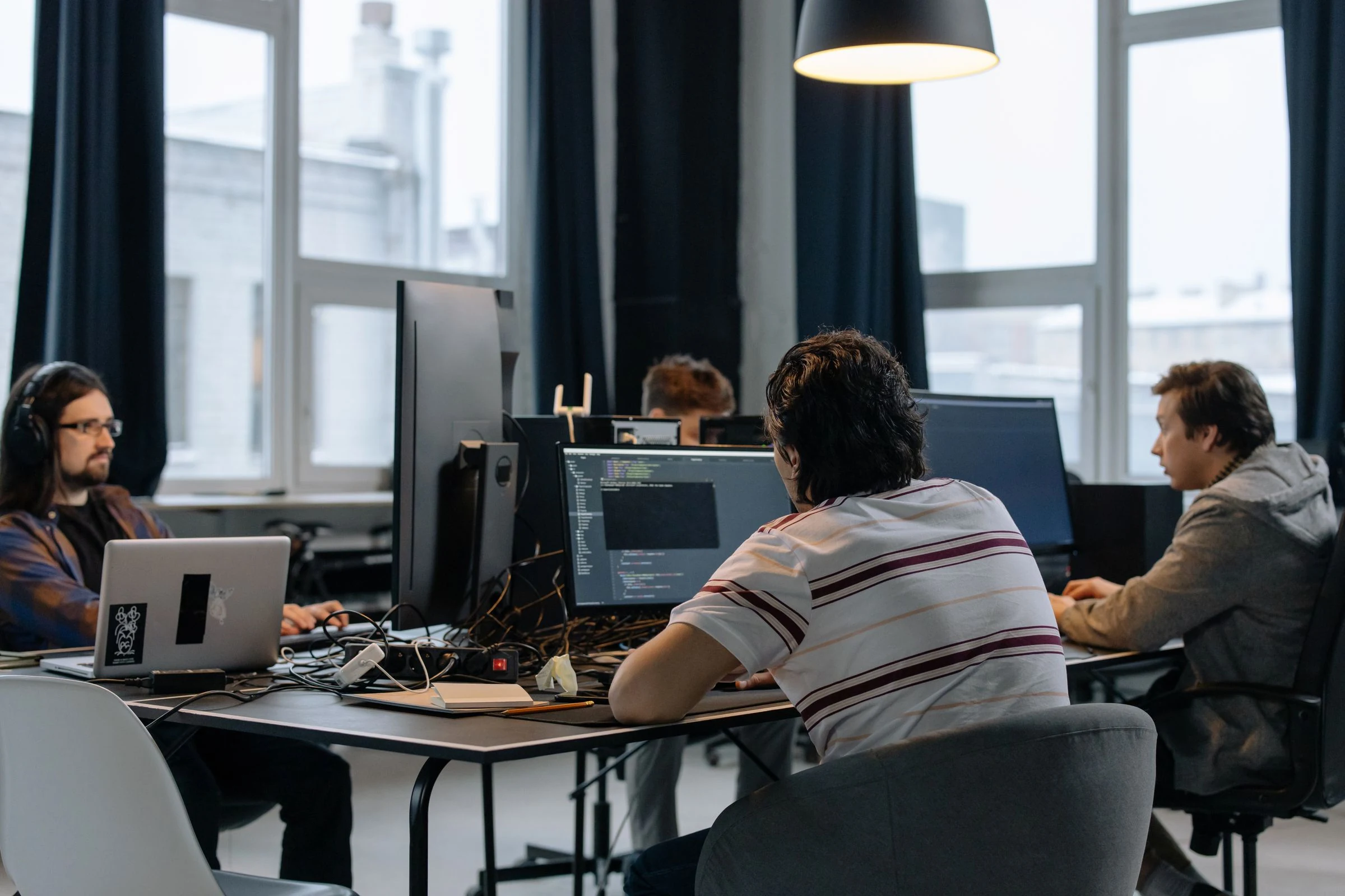 Software professionals working together at engineering workstations in a contemporary office